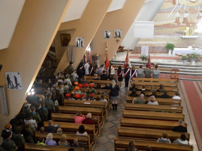 Uczestnicy Uroczystej Mszy świętej siedzą w ławkach. Po lewej stronie stoją harcerze Hufca ZHP Węgierska Górka.